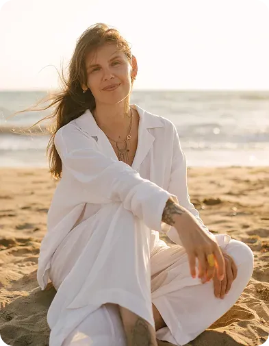 A woman enjoying a calm moment on the beach at sunset
