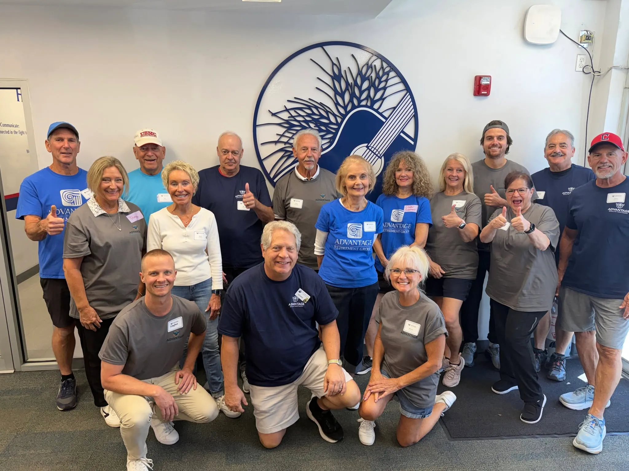 The Advantage Wealth Partners team and their clients gathered for a volunteer day at the Harry Chapin Food Bank of Southwest Florida, in front of the food bank's wheat sheaf emblem