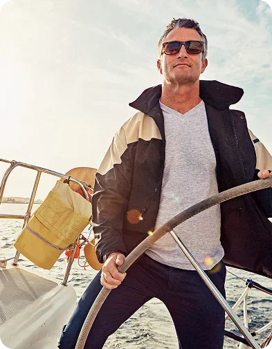 A man at the helm of a sailboat